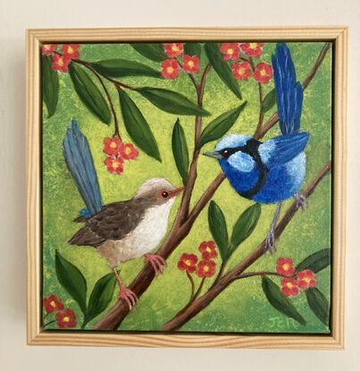 Two blue wrens, a male and a female, sitting in a tree surrounded by leaves and orange flowers. The background is a yellow-greenish colour which contrasts nicely with the blue of the birds and the orange flowers. The colour is wrapped around the sides of the canvas.