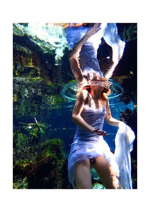 An underwater scene with a woman in a white dress walking gracefully through the water. 