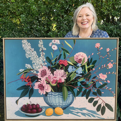 A still life painting of flowers and fruit in blues, reds, oranges, yellows, whites, pinks and greens, framed in oak