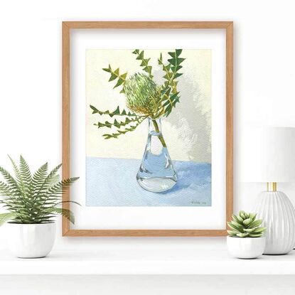 Green banksia flower in vase on blue