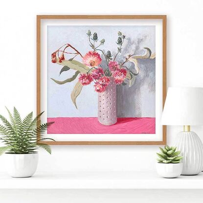 Pink daisy flowers and gum bouquet in white vase on pink background