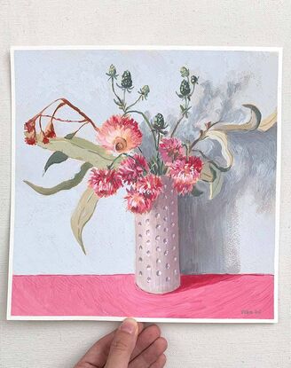 Pink daisy flowers and gum bouquet in white vase on pink background