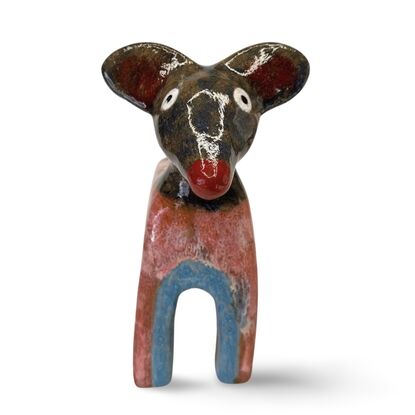 This stoneware sculpture features a stylised puppy distinguished by its vibrant, multi-colored glaze and  large ears and a pronounced snout. The colour and simple form highlight the fun nature of the piece.