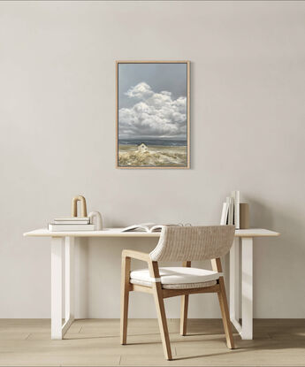 Lonely white shack on beach with puffy white clouds.