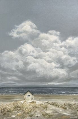 Lonely white shack on beach with puffy white clouds.