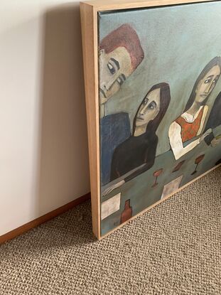 The painting depicts a  group of men and women standing around a table. There are wine glasses and bottles on the table. The people are at a party.