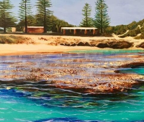 The Basin swimming area at Rottnest Island, with the sheds and pine trees in the background. The foreground features the reef surrounding the island, a favourite swimming and snorkeling spot for holidaymakers. The reef in the foreground is highlighted by the surrounding turquoise waters.