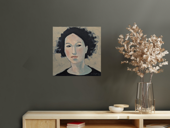 A simple beige background draws the focus onto the face of "Casandra". The dark haired woman is looking off to the side or perhaps behind the viewer. 