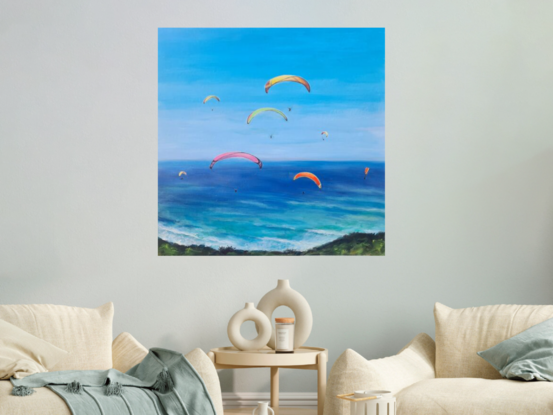 Colourful Paragliders brightly light  a peaceful blue sky, #paragliders soaring High, sailing through a smooth clear blue sky with a #peaceful clear blue ocean greeting them from below.