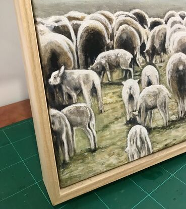 A flock of sheep grazing in an amber field. Lambs in the foreground.  Winter landscape