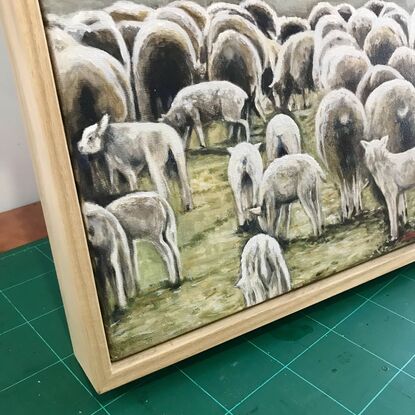 A flock of sheep grazing in an amber field. Lambs in the foreground.  Winter landscape