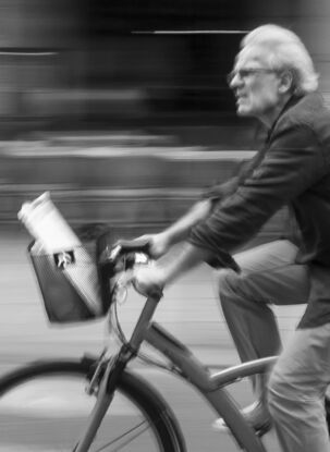 Black and white photograph of cycling in street Paris, France