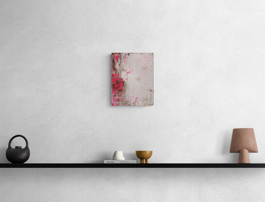 An old worn white wall that has fresh pink blooms starting to grow,