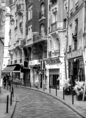 Black and white photograph of curved street in Paris, France