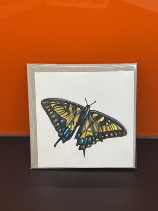 Mini watercolour painting of a butterfly on paper.