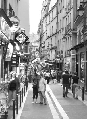 Black and white photograph of narrow street in Paris, France