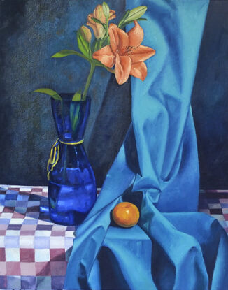 Orange lily in blue vase and an orange mandarin trying to hide in a silky turquoise blue fabric