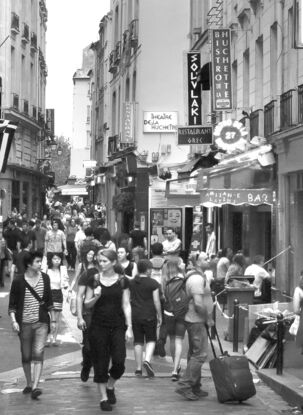 Black and white photograph of narrow street in Paris, France