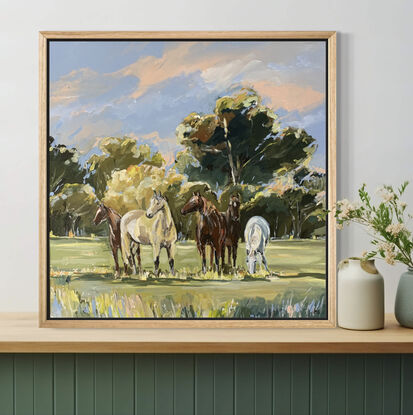 Five thoroughbred horses stand together in a grass country paddock. Blue and pink sky’s peak through the trees.