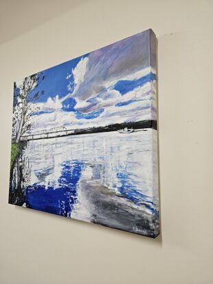 Landscape painting of the Murray River. There are white clouds in the sky which are reflecting in the royal blue water. The painting is mostly royal blue and white. There is a riverbank to the left side with a gum tree overhanging the water. The trees reflections are in the water. A small boat can be seen in the distance.