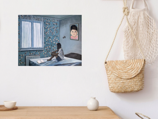 A girl sits on a bed hugging her knees beside a window  in a room decorated with floral wallpaper and a large portrait of a young child. At her feet are the open pages of a blank book.