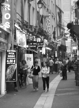 Black and white photograph of narrow street in Paris, France