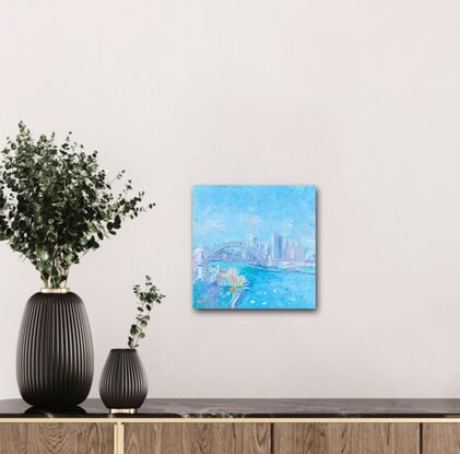 An impressionist oil painting of Sydney Harbour, the Bridge, Luna Park and Sydney skyline. The Sydney scene was painted soft blues with a palette knife for a thick textured artwork. 