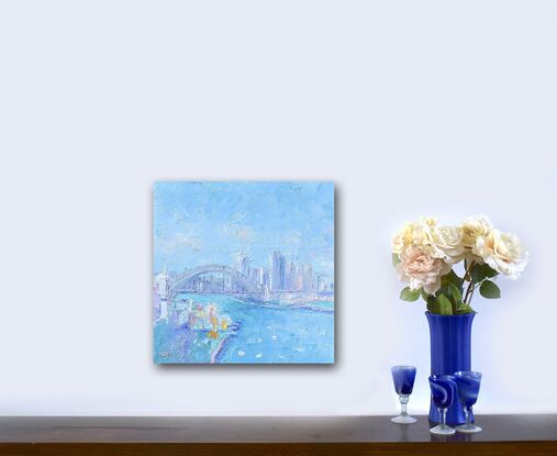 An impressionist oil painting of Sydney Harbour, the Bridge, Luna Park and Sydney skyline. The Sydney scene was painted soft blues with a palette knife for a thick textured artwork. 