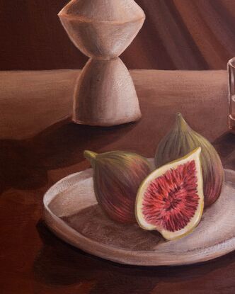 A side lit table scene with long shadows & a beam of light. A plate with figs in the foreground with a white modern vase, glass bottle and drinking glass with water in it.