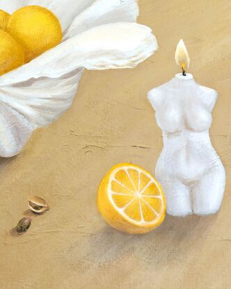 A clam shell holding juicy lemons sits behind scattered pistachios and a lit candle in the shape of a woman on a textured beige yellow background.