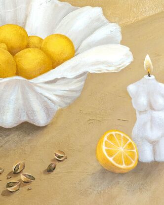 A clam shell holding juicy lemons sits behind scattered pistachios and a lit candle in the shape of a woman on a textured beige yellow background.