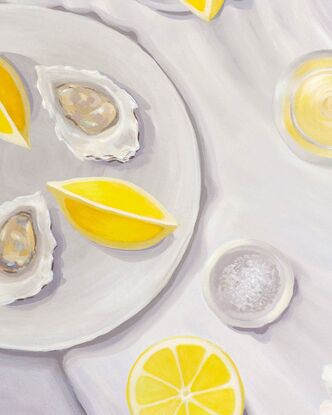 A tabletop view from above showing juicy lemons, oysters, a bowl of salt, and oyster shucker & a seashell.