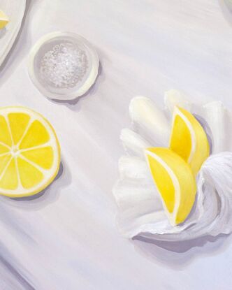 A tabletop view from above showing juicy lemons, oysters, a bowl of salt, and oyster shucker & a seashell.