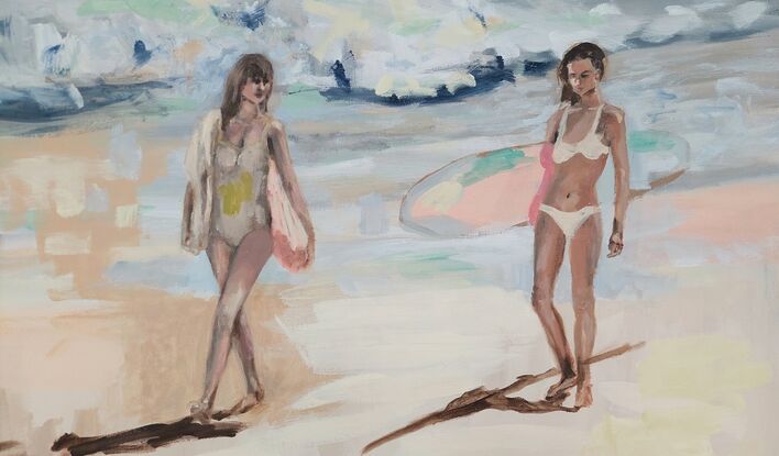 Three women walk along beach.