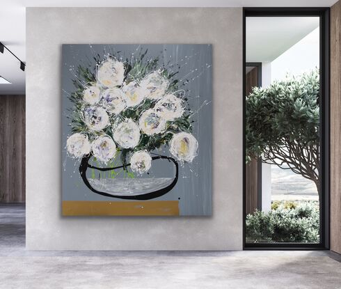 Large white abstract flowers in an organic black vase, sitting on a gold shelf.  Medium grey background.  A largescale statement piece with natural tones.