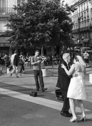 Black and white photograph of wedding couple dancing in street, Paris, France