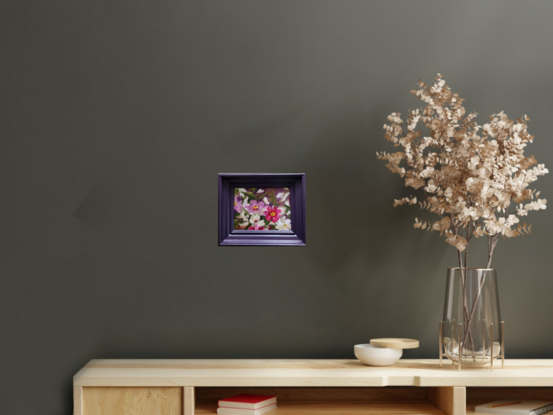 Spontaneous detail of colourful Ranunculi flowers in a matching plum-coloured frame