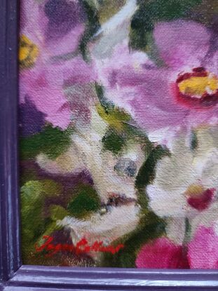 Spontaneous detail of colourful Ranunculi flowers in a matching plum-coloured frame