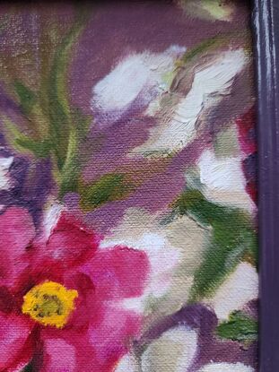 Spontaneous detail of colourful Ranunculi flowers in a matching plum-coloured frame