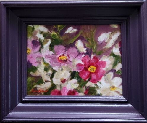 Spontaneous detail of colourful Ranunculi flowers in a matching plum-coloured frame