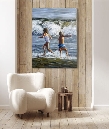 A young boy and girl run in opposite directions arms out flung as they face a wild breaking wave. The ocean is a churning mass of water and the last light of the day paints the children gold.