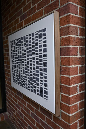 A grid of rectangles of different sizes formed in textured modelling paste with acrylic paint (black/slate) set against a neutral background of off white.