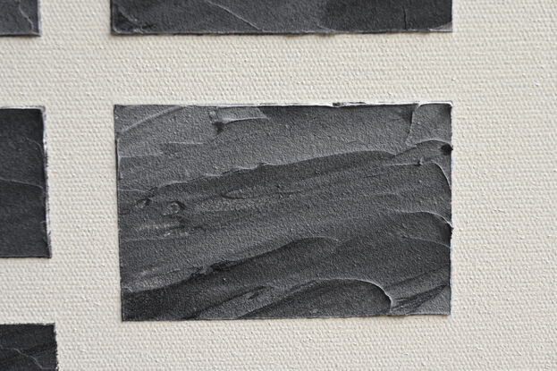 A grid of rectangles of different sizes formed in textured modelling paste with acrylic paint (black/slate) set against a neutral background of off white.