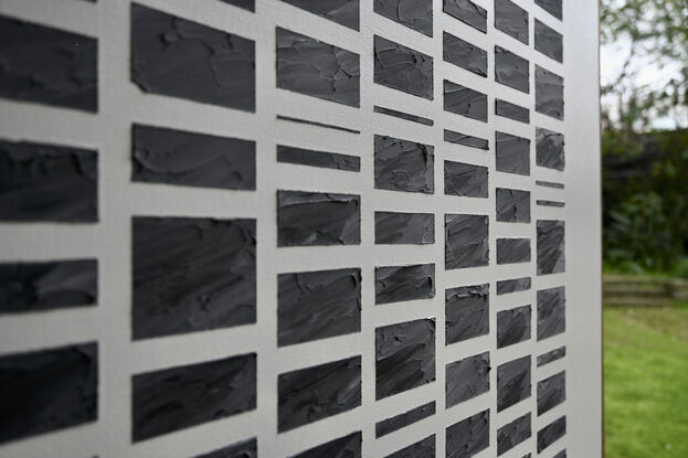 A grid of rectangles of different sizes formed in textured modelling paste with acrylic paint (black/slate) set against a neutral background of off white.