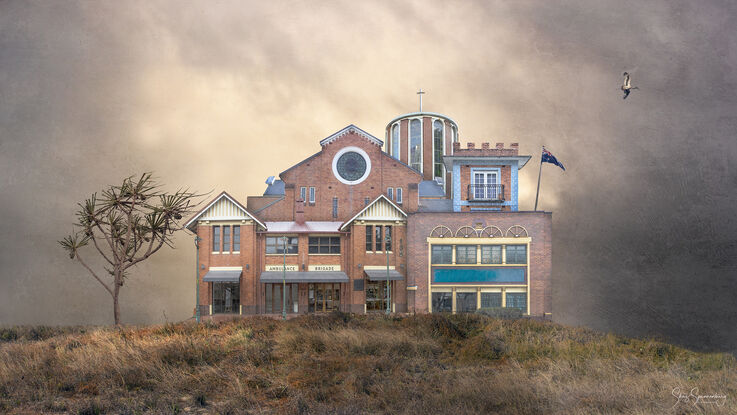 A complex of similar buildings of red brick architecture fused together as one sharing a grassy hill setting and textured moody sky background. A solitary bird flies by plus a lone pandanus palm decorates the hill.