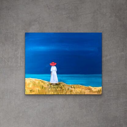 A woman in a red hat looks out to sea.