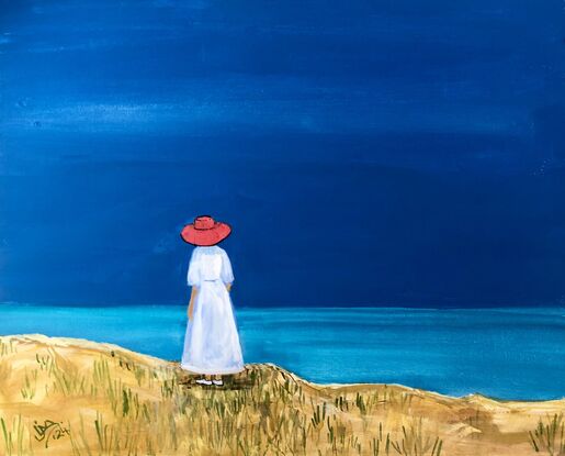 A woman in a red hat looks out to sea.