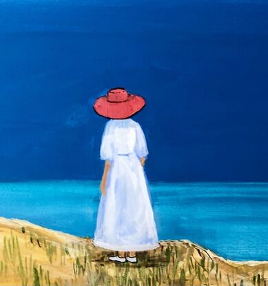 A woman in a red hat looks out to sea.