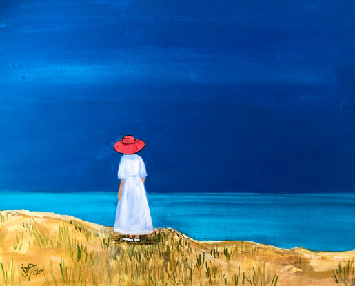 A woman in a red hat looks out to sea.