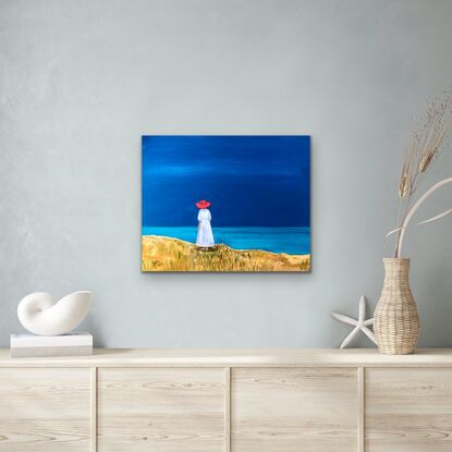 A woman in a red hat looks out to sea.